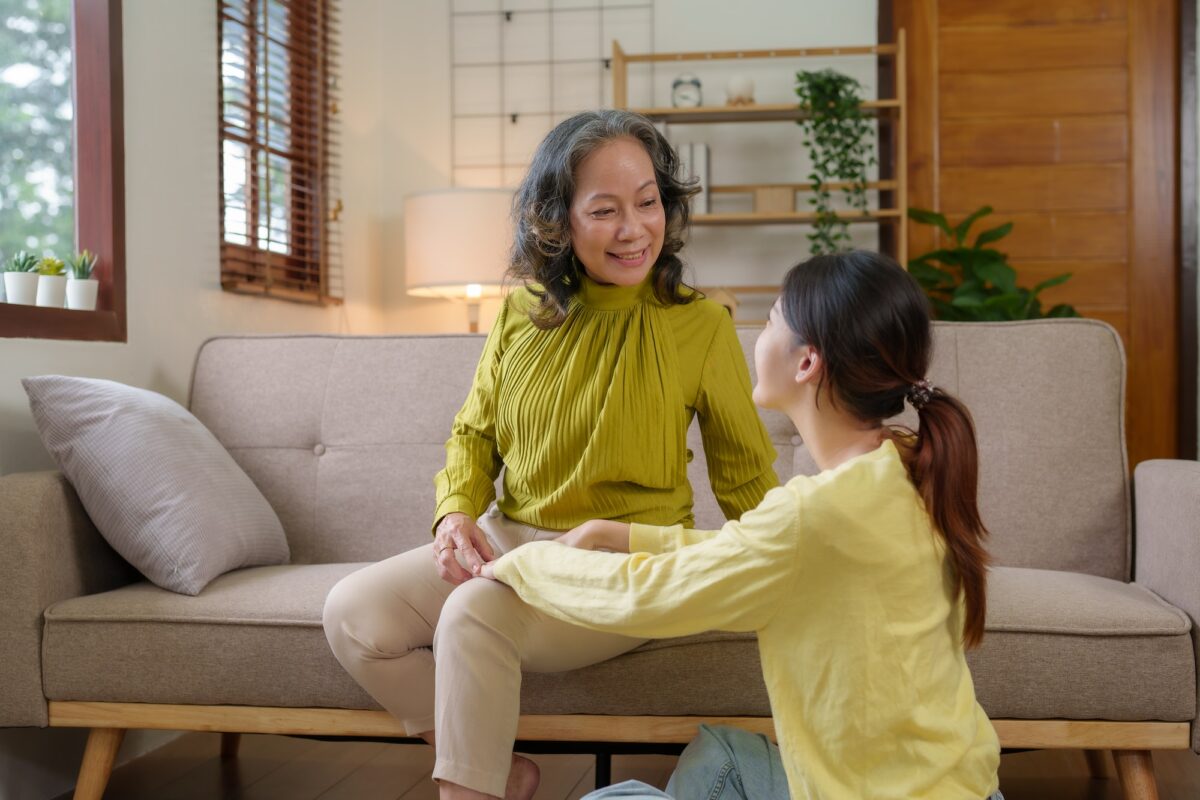Asian caregiver or daughter takes care of the elderly at home in the living room
